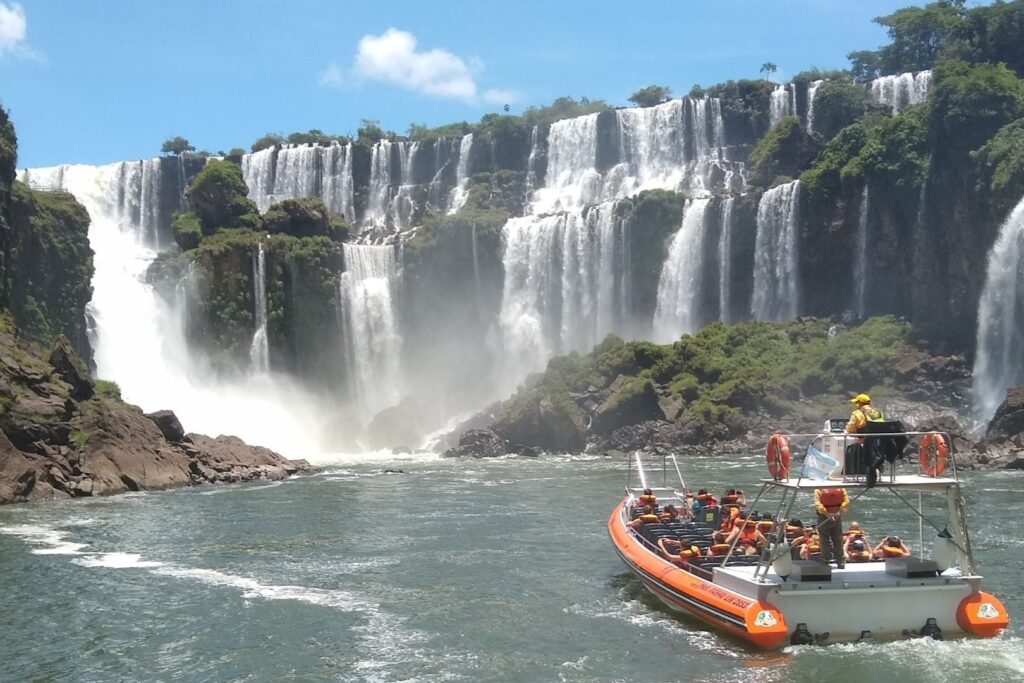 Gran Aventura boat tour approaching the waterfalls at Iguazu Falls with passengers wearing life jackets.