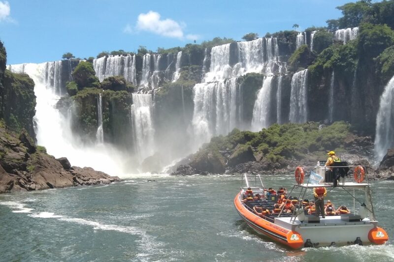 Gran Aventura boat tour approaching the waterfalls at Iguazu Falls with passengers wearing life jackets.